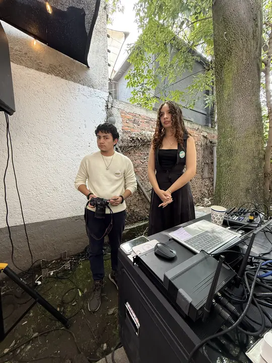Equipo técnico junto a la cabina de audio en el patio del evento.
