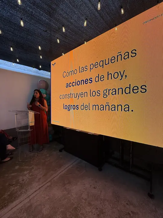 Lámina «Cómo las pequeñas acciones de hoy construyen los grandes logros del mañana» durante una ponencia.