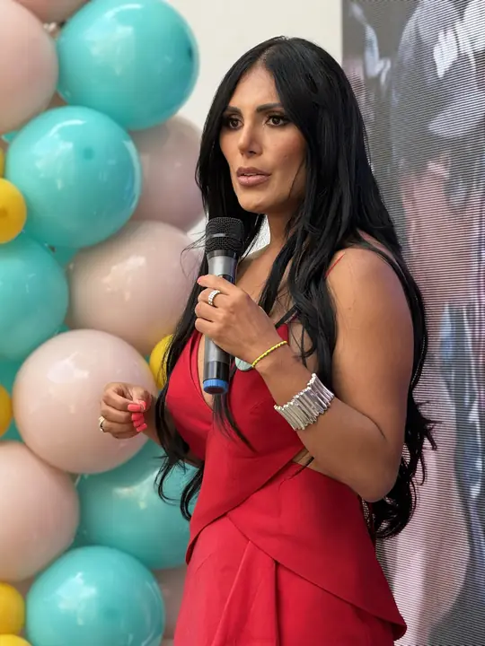 Primer plano de la ponente con vestido rojo durante su intervención.