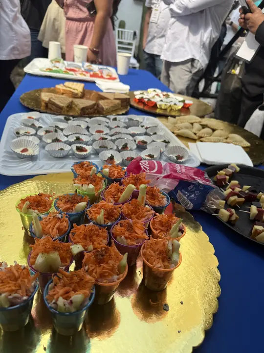 Mesa de bocadillos para las asistentes: tostadas, vasos con verduras y pan.