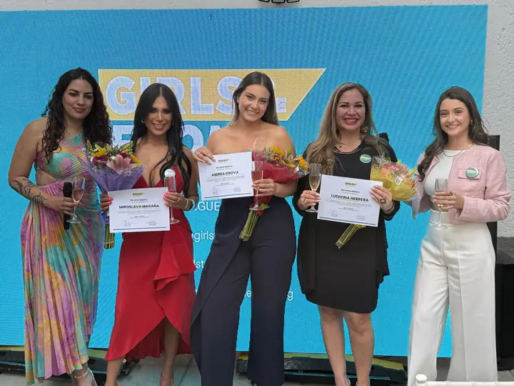 Cinco mujeres posan con reconocimientos y flores al cierre del foro.