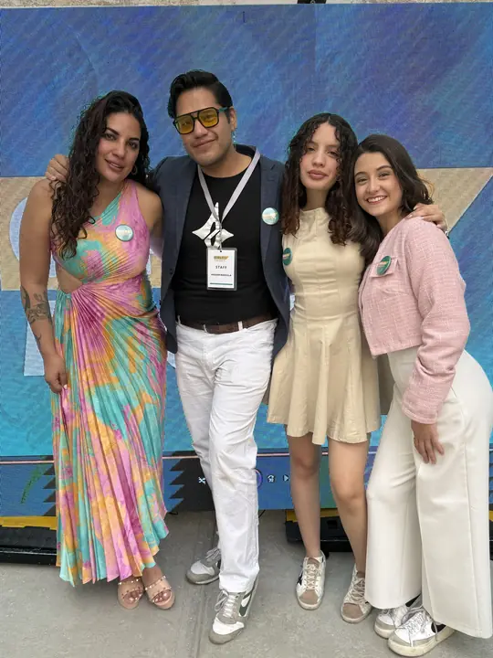 Grupo de asistentes sonríe frente a la pantalla del evento.